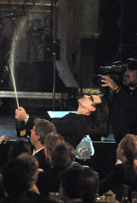 Bono opens a bottle of champagne