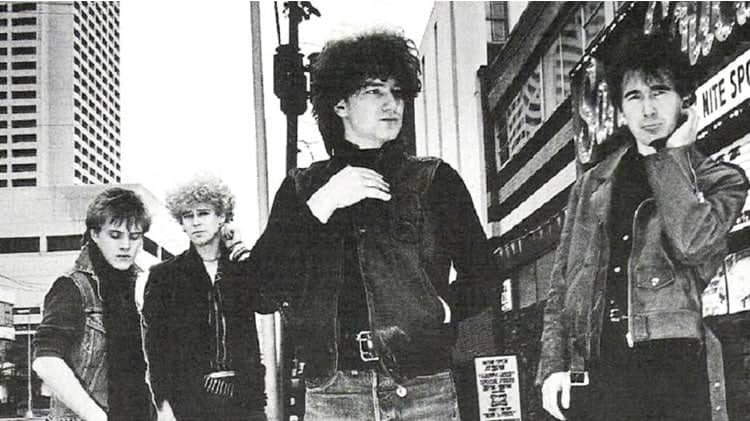 Black leather jacket worn by a man with curly hair.
