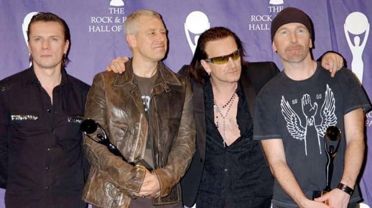 The group of five men, dressed in dark clothing and holding trophies.
